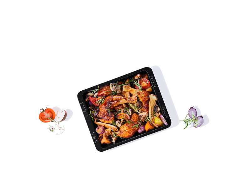 Poulet rôti avec des champignons, des tomates et des oignons dans un plat à four.