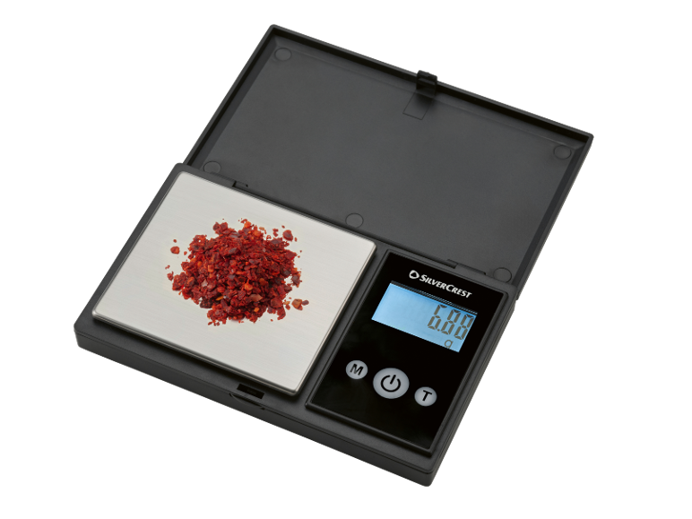 Balance de cuisine numérique avec flocons de piment rouge, affichant 0,00 g.
