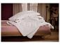 Oreillers et couettes Polygiene sur un lit rose.