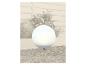 Lampe de jardin sphérique sur fond de clôture en bois et de plantes.