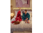 Un homme et une femme en pyjama à carreaux festif se détendent sur un lit avec du linge de lit de Noël.