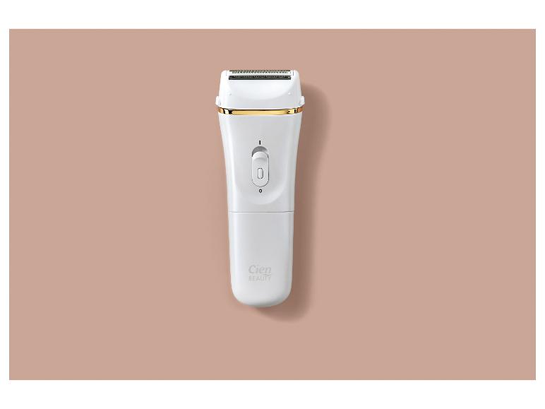 Rasoir électrique blanc avec des accents dorés sur un fond beige.