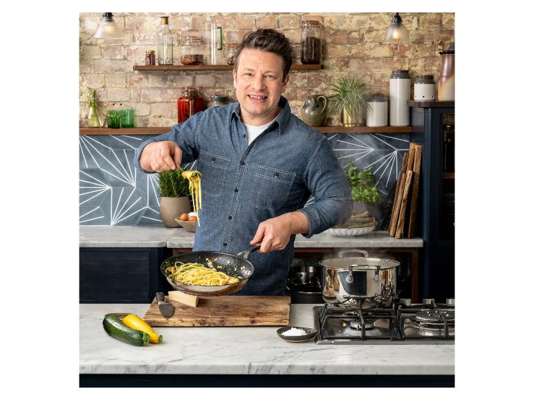 Jamie Oliver cuisinant des pâtes dans une cuisine avec des murs en briques et des comptoirs en marbre
