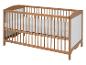 Un lit bébé en bois avec un matelas.