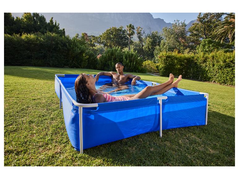 Couple se relaxant dans une piscine hors sol bleue dans un jardin ensoleillé.