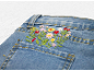Jean en denim bleu avec broderie florale colorée sur la poche arrière.