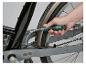 Main utilisant un tournevis flexible pour ajuster un vélo.