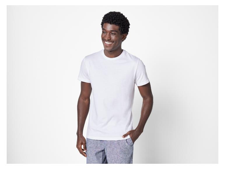 Un homme portant un t-shirt blanc et un pantalon bleu.