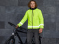 Un homme avec une veste réfléchissante et un vélo noir.