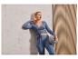 Une femme en tenue de yoga bleue tient un ballon de pilates.