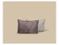 Deux coussins à motif de feuilles, un plus foncé et un plus clair, sur fond beige.