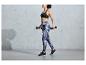 Une femme portant un soutien-gorge de sport noir et un legging à imprimé soulève des poids.