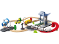 Ensemble de jouets trains et voitures avec gare, rails en bois et route.