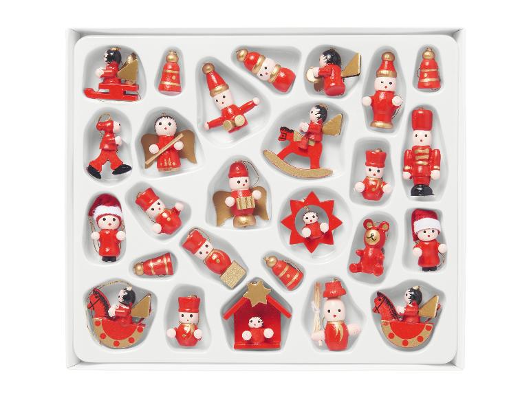 Un ensemble d'ornements de Noël en bois rouges et dorés dans une boîte blanche.