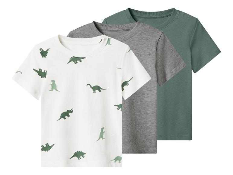 Trois t-shirts à manches courtes pour enfants : un blanc avec des dinosaures verts, un gris et un vert.