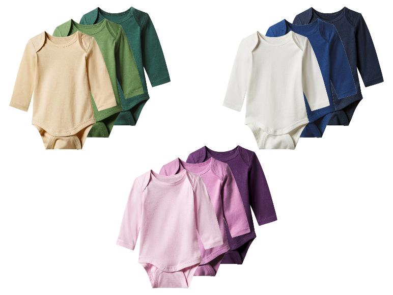 Trois ensembles de bodys de bébé à manches longues en couleurs assorties.