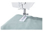Une machine à coudre cousant un morceau de tissu bleu clair.