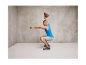 Homme en débardeur bleu d'entraînement faisant des squats avec une kettlebell.