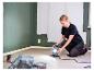 Femme peignant une pièce avec une lampe de travail LIVARNO®.