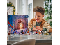 Un garçon joue avec un calendrier de l'Avent de jouets sur la table.