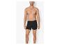 Homme torse nu, portant un boxer noir, sur fond blanc.