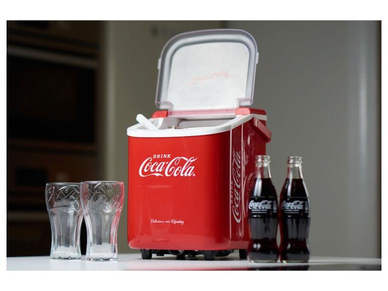 Une glacière Coca-Cola rouge avec deux bouteilles de Coca-Cola et deux verres.
