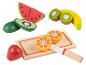 Jouets en bois en forme de fruits, dont une pastèque, un kiwi, une banane, un avocat, une orange et une fraise.
