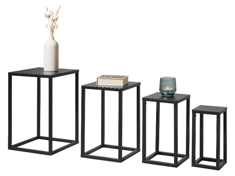 Ensemble de quatre tables d'appoint en métal noir de différentes hauteurs avec objets décoratifs.