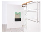 Cuisine avec une armoire ouverte, contenant deux planches à découper et une carafe en verre.