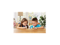 Deux enfants souriants jouent avec des figurines d'animaux sur une table en bois.
