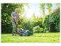 Un homme tond sa pelouse avec une tondeuse Parkside.