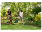Couple dans un jardin avec tondeuse, coupe-bordure et cisaille à gazon.