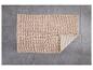Un tapis de bain beige avec une texture douce.