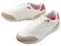 Des baskets blanches avec des détails beiges et des accents rouges.