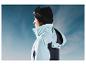 Une femme porte une veste de ski bleue avec capuche et un bonnet noir de Crivit.