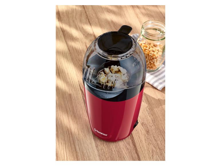 Machine à popcorn SilverCrest rouge avec du popcorn éclaté et des grains de maïs dans un bocal.