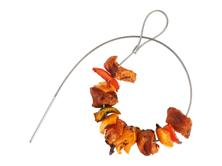 Des morceaux de viande et de légumes grillés sur une brochette en métal.