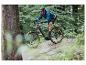 Un homme roule à vélo de montagne électrique gris dans la forêt.