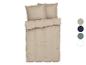 Parure de lit beige avec oreillers.