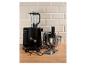 Robot de cuisine noir avec mixeur, bol en acier inoxydable et divers accessoires sur un comptoir en bois.