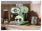Machine à café couleur menthe avec deux tasses d'espresso sur un comptoir en bois.