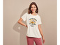 Une femme porte un t-shirt blanc avec un imprimé soleil et fleurs.