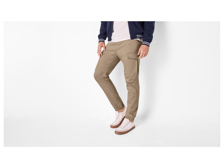 Pantalon cargo kaki et veste bleu marine à rayures blanches.