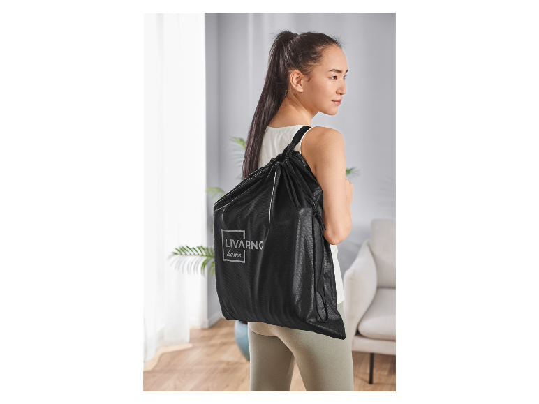 Une femme porte un sac noir Livarno Home.