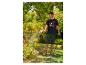 Homme arrosant des fleurs dans un jardin, portant un t-shirt noir 'YOU GOT THIS!' et un short vert.