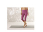 Une femme porte un legging capri rose et se tient debout sur un tapis de yoga.