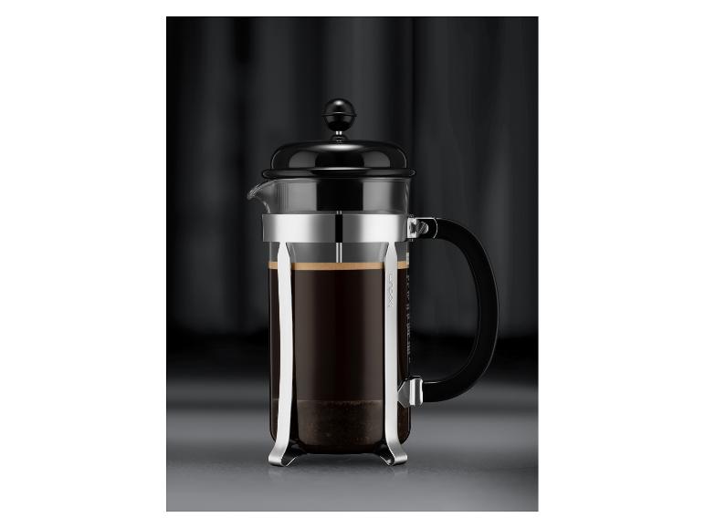 Cafetière à piston noire avec carafe en verre et cadre métallique, remplie de café.