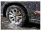 Une voiture noire est nettoyée avec un nettoyeur haute pression Parkside.