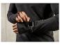 Un homme porte un pull noir et une Apple Watch.