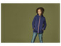 Une fille porte une veste softshell bleue et un jean.